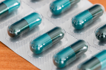 Blue-black medical capsules in a blister pack.