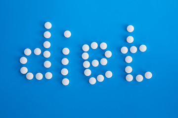 Medical care concept written with pills word DIET On medicine blue background