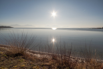 Blick über den Chiemsee bei Gegenlicht und Sonnereflektione