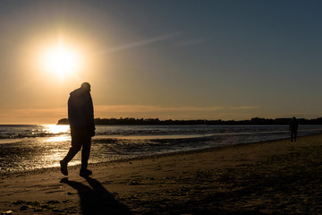 Person silhouette walking on the beach during morning in Puerto Madryn, Patagonia, Argentina