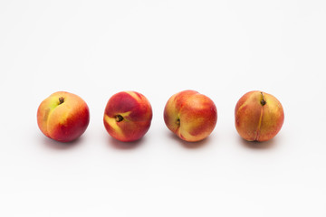 Row of Heavenly ripe peaches on white 
