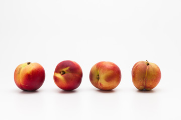 Row of Heavenly ripe peaches on white 