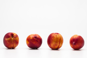Row of Heavenly ripe peaches on white 
