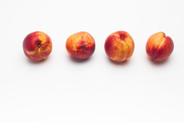Row of Heavenly ripe peaches on white 