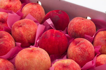 Pile of ripe peaches on a box 