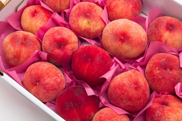 Pile of ripe peaches on a box 