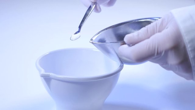 Scoop medicine powder into mortar for making ointments in the pharmacy laboratory