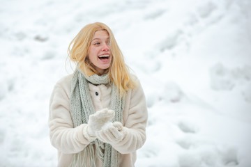 Obraz premium Winter woman. Cute playful young woman outdoor enjoying first snow. Happy woman holds snowball in hands. Snowball.