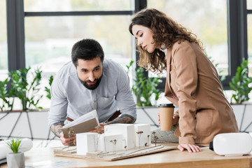 Fototapeta premium virtual reality architects looking at model of house in office