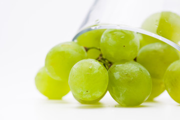  Fresh green grapes with glass cup isolated 