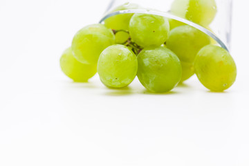  Fresh green grapes with glass cup isolated 