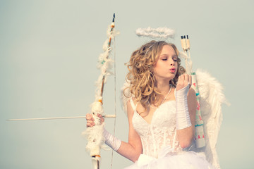 Beauty blue her eyes - charming lady in the sunlight. Angel children girl with white wings. A child...