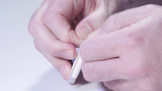 Remove suppository from packaging with male hands