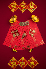 Chinese New Year decorations with red background with assorted festival decorations. Chinese characters means abundant of wealth, prosperity and luck. Flat lay or top view. 