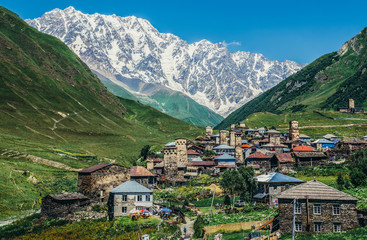Fototapeta na wymiar View of Mount Shkhara and buildings in Ushguli community villages in Svaneti region, Georgia