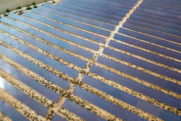 Drone aerial shooting of solar power farm raws of reflective panels. At cloudy day.