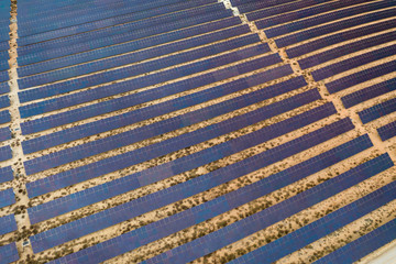 Drone aerial shooting of solar power farm raws of reflective panels. At cloudy day.