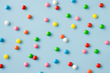 Background of chocolate candy with colored glaze. Scattered multicolored candy.