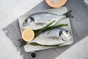 fresh dorado fish with lemon and pepper flat lay