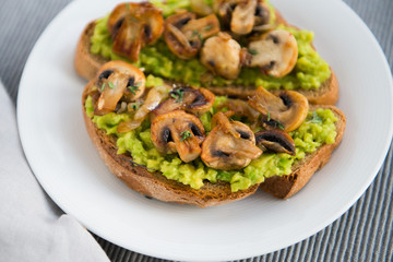 toast with avocado and grilled mushrooms on the dish