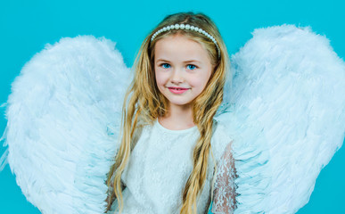 Angel child. Face of beautiful little angel girl on color background. Child wearing long white...