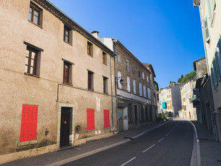 Street with empty road and houses with orange shutters in France