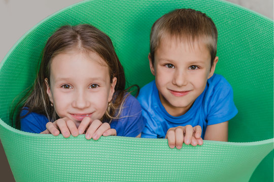 portrait of small children playing at home against a green karimat background. happy brother and sister have fun