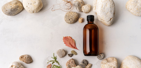 Flat lay composition with brown glass bottles over Natural background of real tree bark, moss on light stone surface with copy space for mocup of body care organic cosmetics. banner.