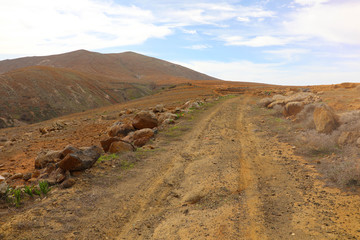 Fototapeta na wymiar Beautiful view of an arid pathway with hills in Fuerteventura, Canary Islands