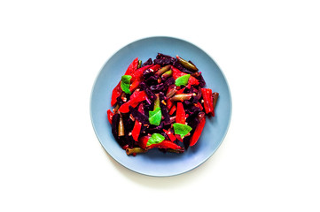 Baked vegetables in blue plate on white isolated background. Health-conscious diet. Budget-friendly menu.Close-up