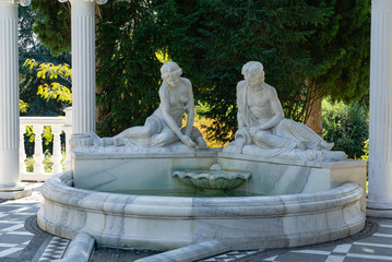 Beautiful white marble fountain with figures from Greek mythology in  Aivazovsky landscape park in...