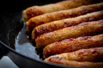 Beef and pork sausages cooked in a pan. Closeup. - Powered by Adobe