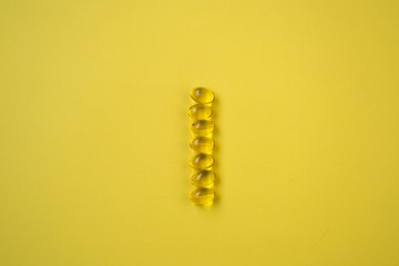 Close-up of golden colored oil supplements, capsule, health concept, pharmaceutical tablets