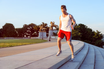Fit Caucasian man running up and down steps for exercise in the early morning in Washington DC.  - 313155845