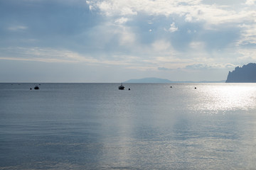 Obraz premium Blue sky with white clouds over the sea and mountains. Two Anchor Bay in Ordzhonikidze, Crimea. Beautiful clouds and natural sky background