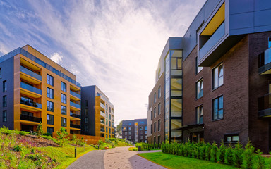 Apartment in residential building exterior. Housing structure at blue modern house of Europe. Rental home in city district on summer. Wall and glass high architecture for business property investment.