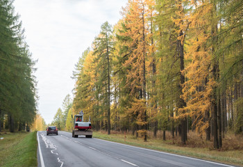 Obraz premium Passenger car using opposing lane while passing a digger