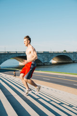 Fit Caucasian man running up and down steps for exercise in the early morning in Washington DC.  - 313157227