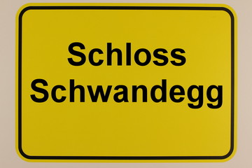 Grafische Darstellung einesOrtseingangsschildes mit der Aufschrift Schloss Schwandegg