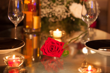 Closeup of rose in a candle light dinner setting. 