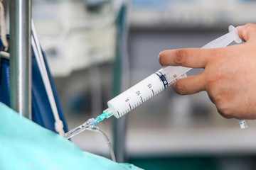 Nurse injecting a drug through an infusion system