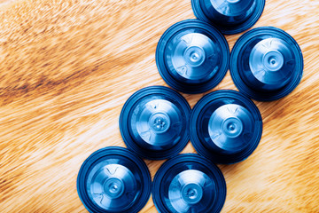 Espresso coffee capsules or pods and coffee beans on wooden rustic background