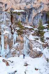 Fototapeta na wymiar man walks on frozen lake Braies in Italy in winter, concept of winter travel