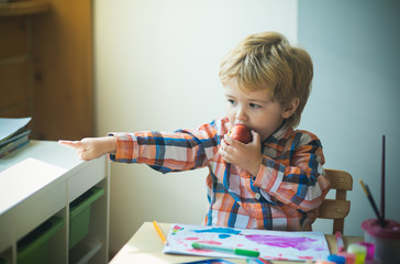 Boy with an apple. Snack in the childrens room.