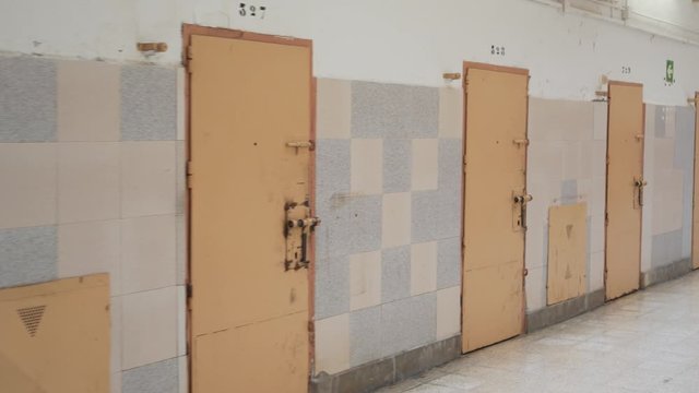 row of prison cell doors. the camera moves slowly along the prison corridor