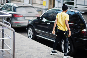 African man wear on black hat posed outdoor against business car.