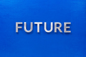 the word future laid with silver metal characters on blue board in flat lay centered composition