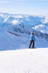 Fototapeta na wymiar Man Skier skiing in Hintertux Glacier in Tyrol in Mayrhofen in Austria, winter Alps. People Ski at Hintertuxer Gletscher in Alpine mountains with white snow and blue sky. Austrian snowy slopes