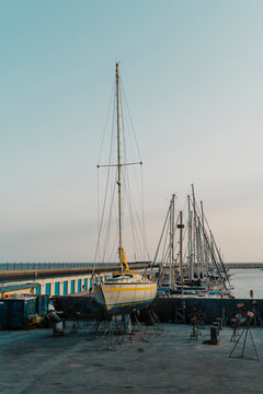 Yachts moored in shipyard harbor