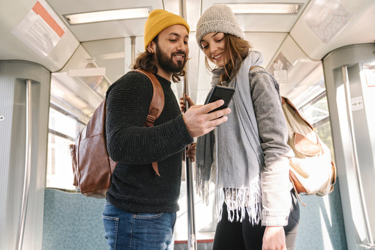 Young couple using smartphone on a subway